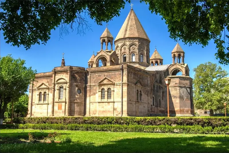 نمای بیرونی کلیسای جامع اچمیادزین در میان باغی سرسبز و در یک روز آفتابی
