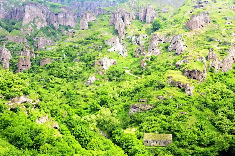 تصویری از خانه‌های غاری روستای خندزورسک در دره‌ای سرسبز