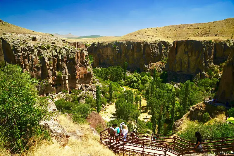 گردشگران در حال پیاده‌روی در دره عمیق و سرسبز ایهلارا، یکی از جاذبه‌های طبیعی کاپادوکیا