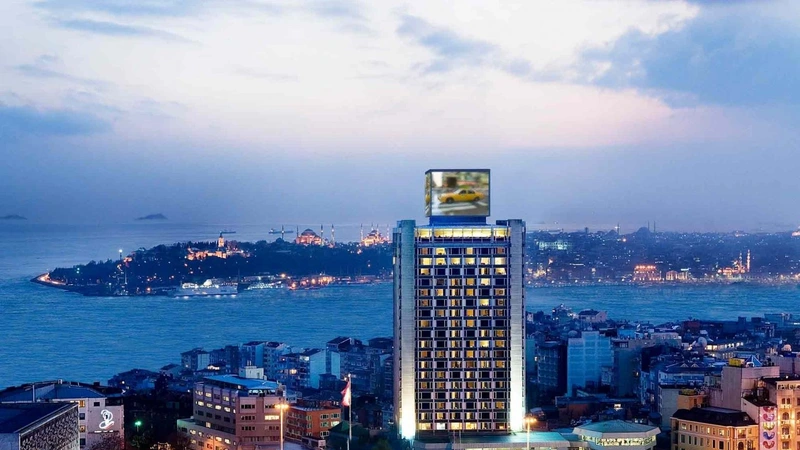 نمای بیرونی هتل مارمارا پرا هنگام غروب، با منظره پانورامیک تنگه بسفر و شبه‌جزیره تاریخی استانبول در پس‌زمینه.