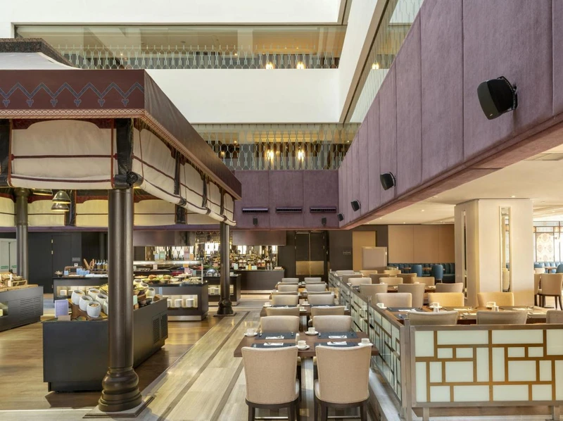 سالن رستوران مدرن هتل بارسلو استانبول، با میزهای چیده‌شده برای غذاخوری و بوفه سلف‌سرویس در سمت چپ.