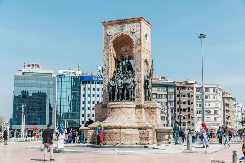 نمایی از مجسمه جمهوریت (Cumhuriyet Anıtı) در مرکز میدان تکسیم استانبول، با حضور گردشگران و ساختمان‌های مدرن اطراف در پس‌زمینه.