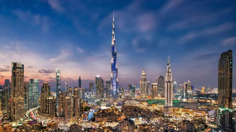 تصویری از برج خلیفه (Burj Khalifa)، بلندترین ساختمان جهان، با  منظره‌ای از مرکز شهر دبی هنگام غروب.