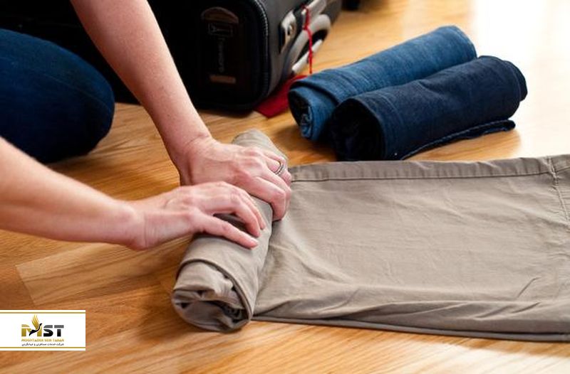 رول کردن لباس‌ها در چمدان